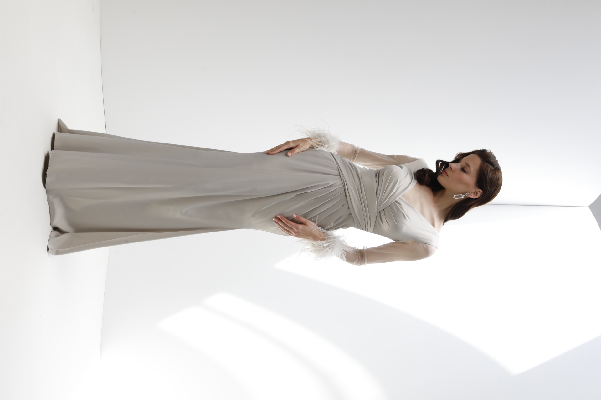 Champagne satin gown with sheer sleeves and feather cuffs