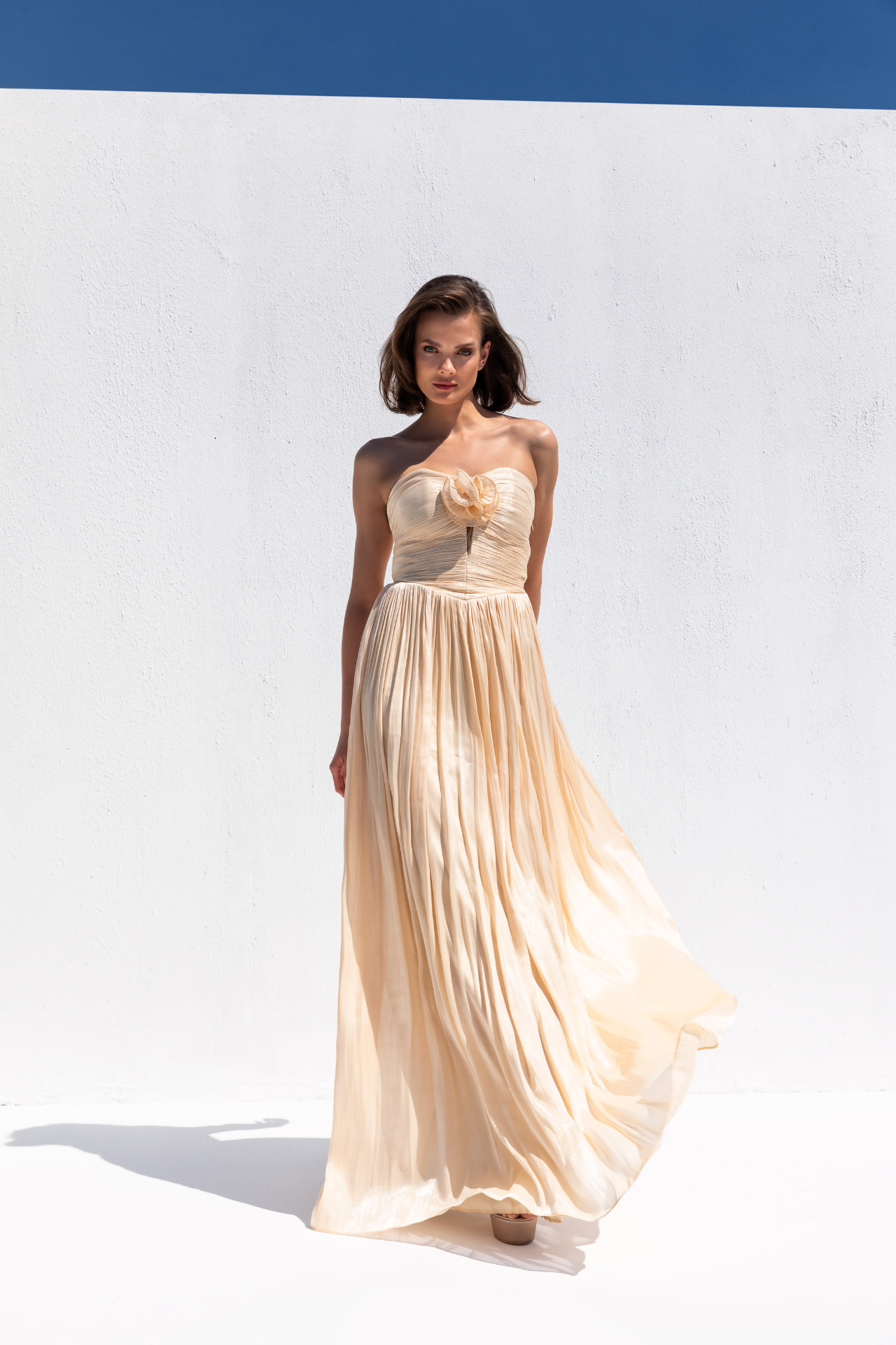 Champagne pleated chiffon strapless gown with rosette bodice detail
