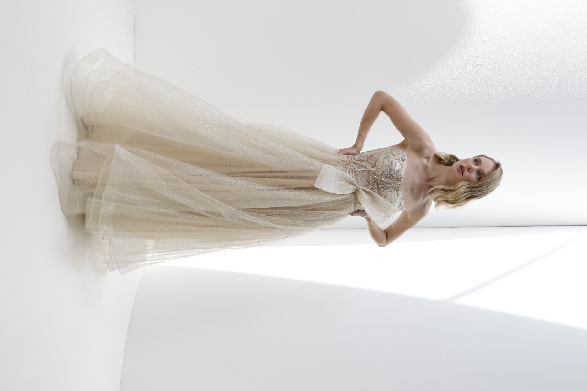 Champagne strapless tulle A-line gown with beaded corset bodice and bow